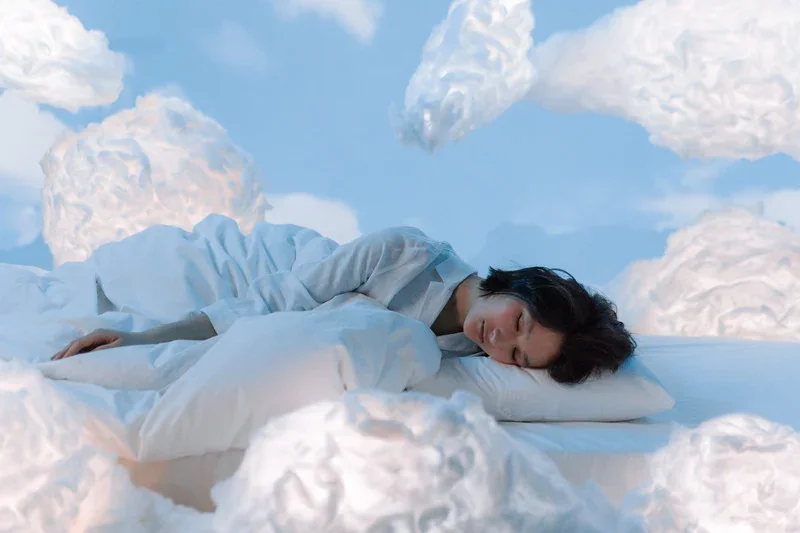 femme endormie dans les nuages : l'importance du sommeil